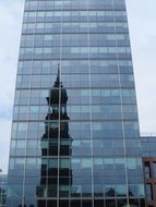 reflection of the tower St. Michael's Church on the facade of a skyscraper in Hamburg