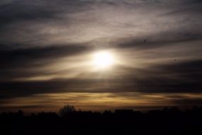 bright sun in the clouds above the houses