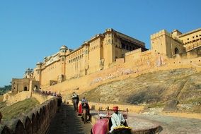 people descend on elephants on the stairs of the palace in Rajasthan, India