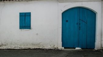 blue shutters and gate in white wall, cyprus, xylotymbou