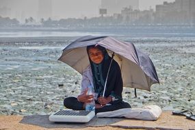 smiling beggar Girl under Umbrella onstreet, india, mumbai