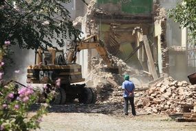 demolition of a house by a bulldozer