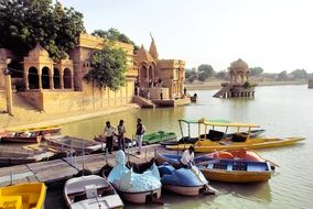 multi-colored boats at the pier of the temple in Rajasthan, India