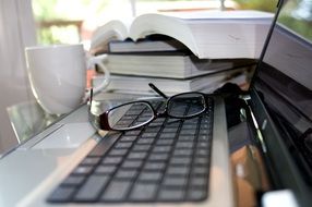 books and glasses near the computer