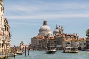 boats on a canal between houses in venice