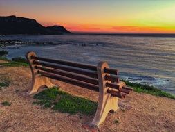 bench on the ocean at sunset