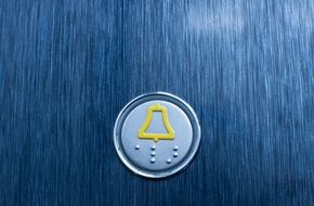 elevator button on a blue wall