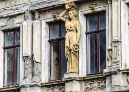 female statue on the facade of an old house