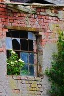 broken window on the facade of an abandoned house