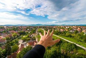 picture of man's hand over green cityscape