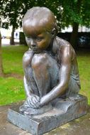 bronze statue of a sitting child