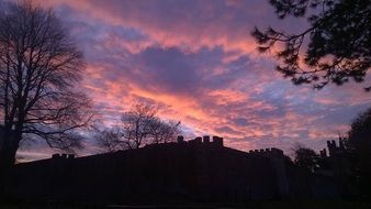 silhouettes of a castle on a hill at a bright sunset