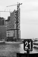 black and white photo of a construction crane near the river