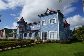wooden house with blue walls near the green field