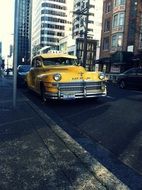 yellow taxi on the side of the road