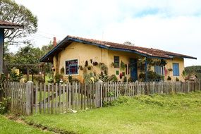 landscape of cute rural house with a fence