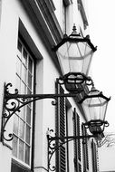 Black street lights on the facade of the white house