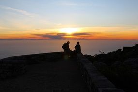 silhouettes of two persons in front of ocean at sunset, south africa, cape town