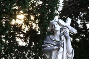 statue with a cross in a cemetery