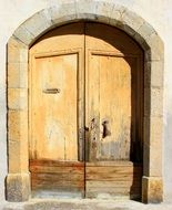 arched front wooden door in the sunlight