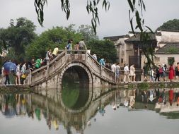 tourists on a stone bridge in Tunxi District, China