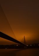 bridge over river under orange sky at sunset time