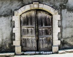 Old arched Wooden gate in stone wall, cyprus, anafotia