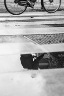 black and white photo of a bicycle at a pedestrian crossing