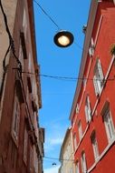narrow street between rows of houses on a sunny day