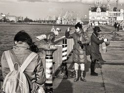 black and white photo of people on the embankment in the rain