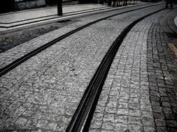 rails on the pavement in black and white image