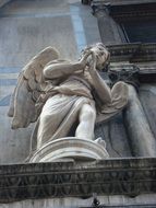 stone sculpture of an angel on the facade of the cathedral