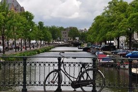 Bike on bridge at fence in cityscape