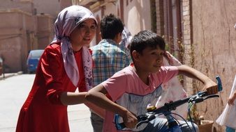 children on a bike on a city street in china