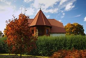 red brick building with tile roof in colorful autumn garden