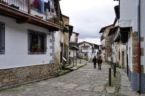 tourists walk along a cobbled street in Spain