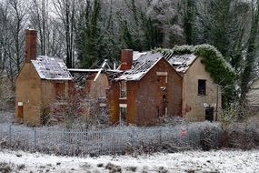 landscape of abandoned old house in snowy forest