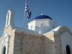 white church with blue dome in greece