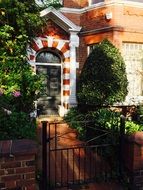 doorway to a brick house among green trees