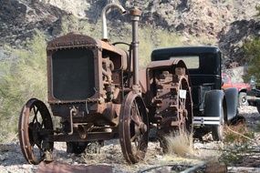 rusty tractor near the antique car