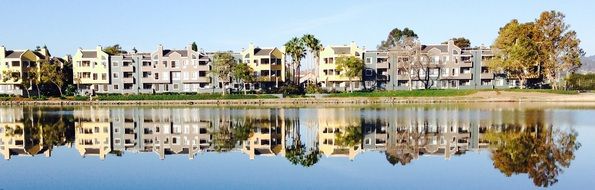 row of apartment Buildings mirroring on calm water