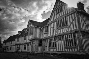 clouds over a medieval log house, black and white