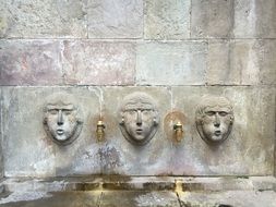 stone faces on the fountain in Barcelona