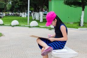 girl in pink cap reading