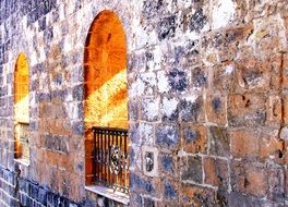 windows in the form of arches on a stone wall