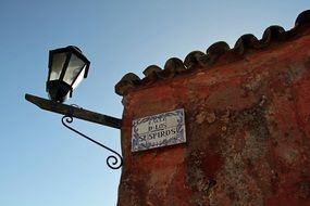 street lamp on the wall of an old building in uruguay