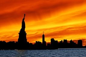 silhouette of statue of liberty at colorful sky background with the clouds