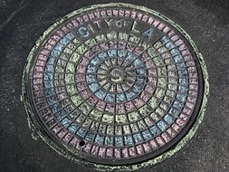 Colorful sewer hatch painted with chalk