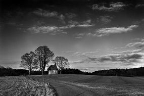 black and white photo of a chapel in a field