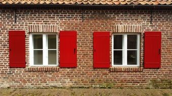 windows with red shutters of a brick house